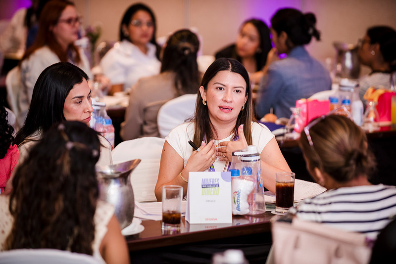 Women talking around a table at the launch in Managua